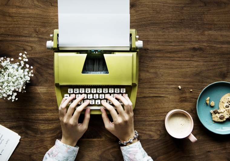 top-view-woman-typing-retro-typewriter-blank-paper